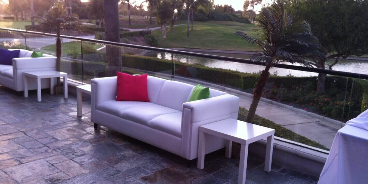 A white couch with pillows on top of it.