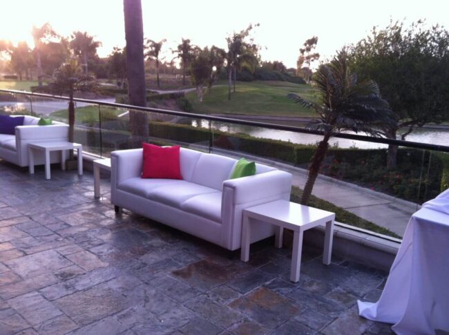 A white couch with pillows on top of it.