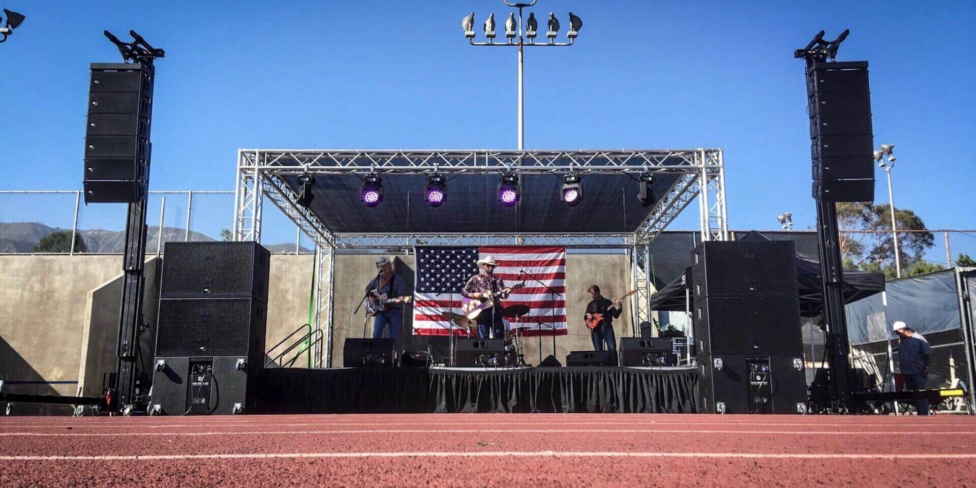 A band performing on stage under an american flag.