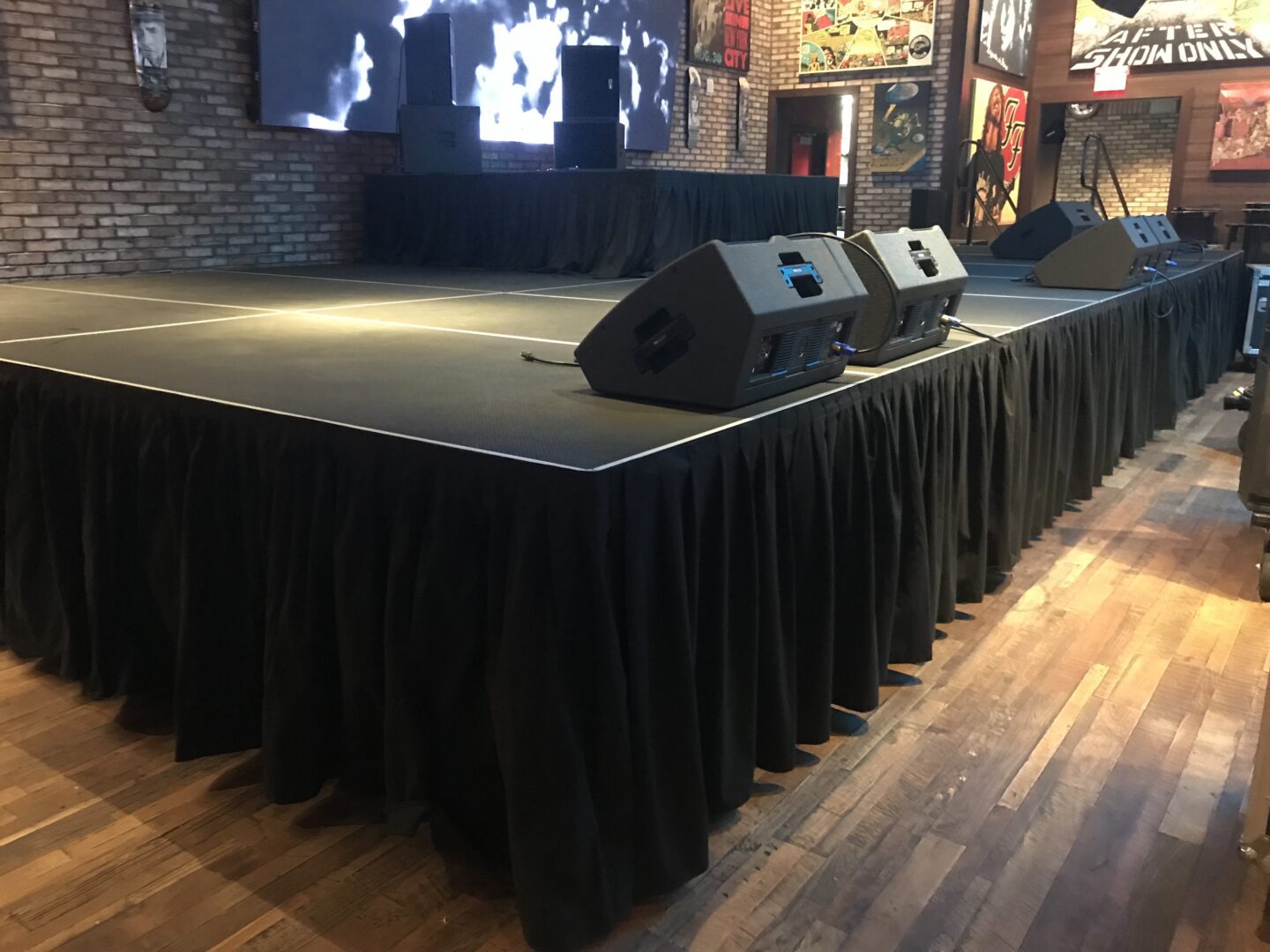 A closeup shot of a performance floor with music systems and large screen